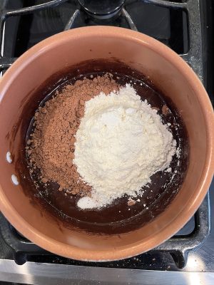 A copper pot with a brownie mixture being cooked
