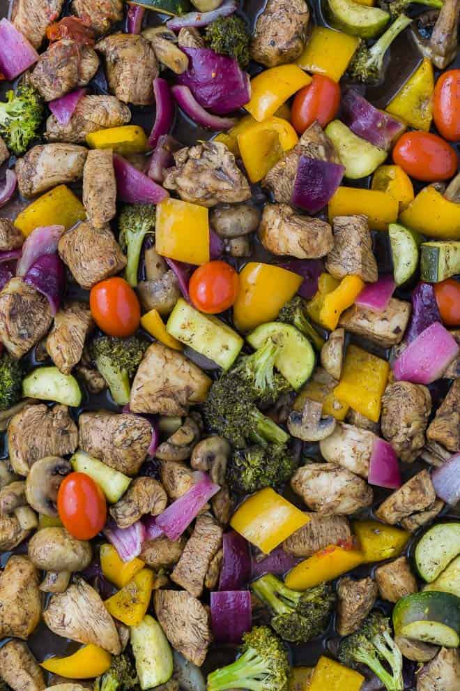 A sheet pan dinner with balsamic chicken and mixed colorful vegetables