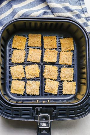Breaded ravioli in an Air Fryer tray before being cooked