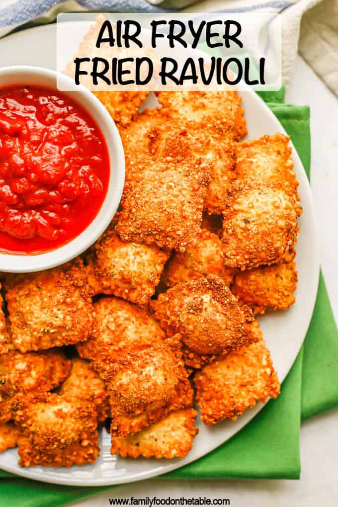 Close up of fried ravioli on a plate with a bowl of marinara and a text overlay on the photo