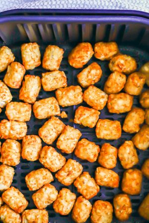 Crispy golden brown tater tots in an Air Fryer tray after cooking