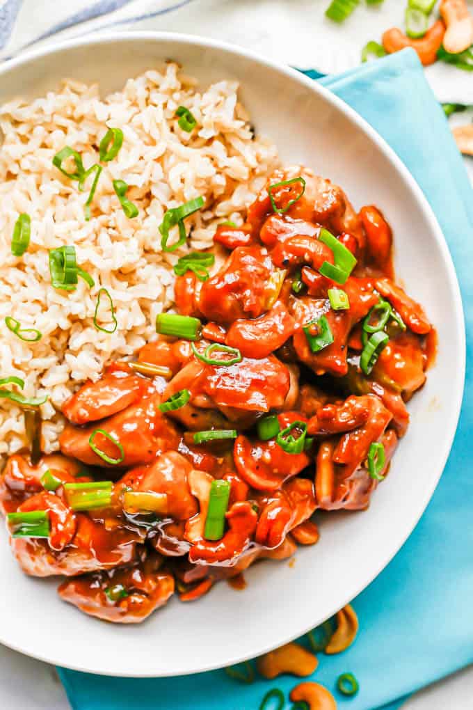 Overhead shot of cashew chicken with rice in a low white bowl