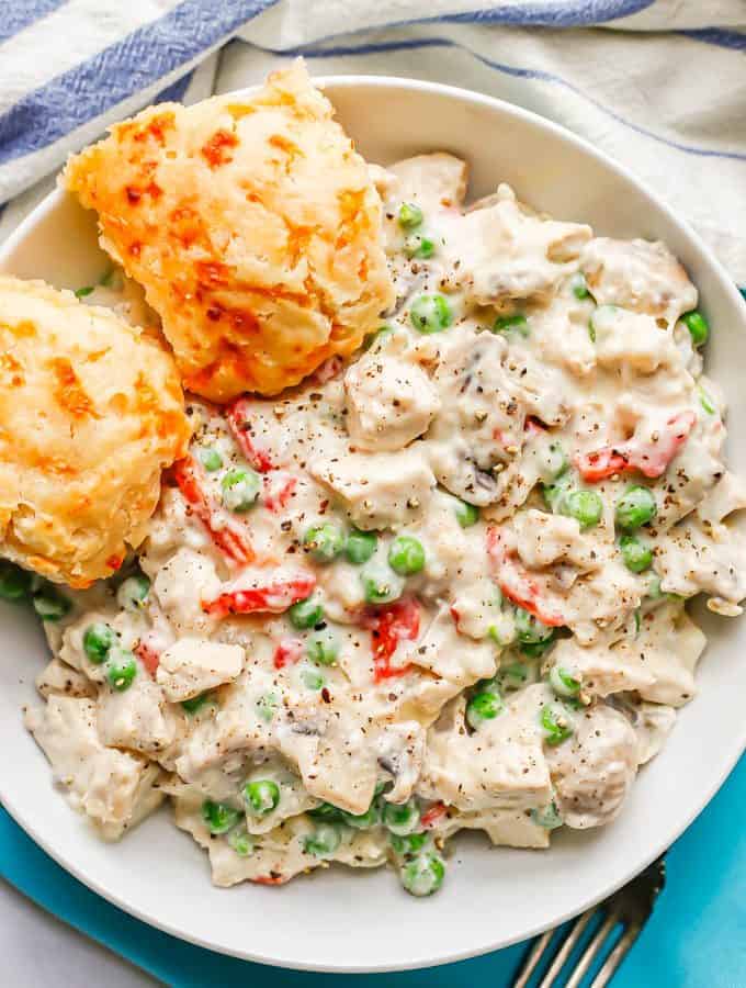 Chicken a la King served with two cheesy biscuits in a low white bowl