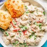 Chicken a la King served with two cheesy biscuits in a low white bowl with a text overlay on the photo