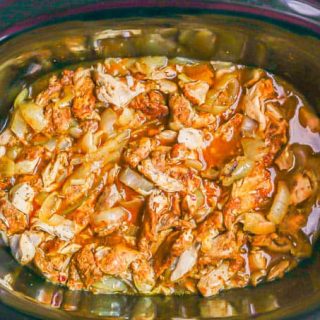Overhead shot of a crock pot with slow cooker chicken shawarma strips and onions