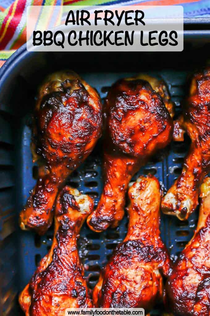 Close up of BBQ basted chicken legs in an Air Fryer after cooking with a text overlay on the photo