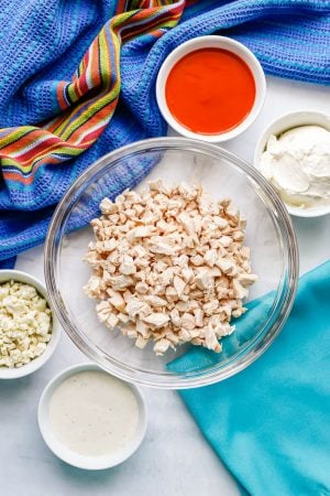 Ingredients laid out in separate bowls for making buffalo chicken dip