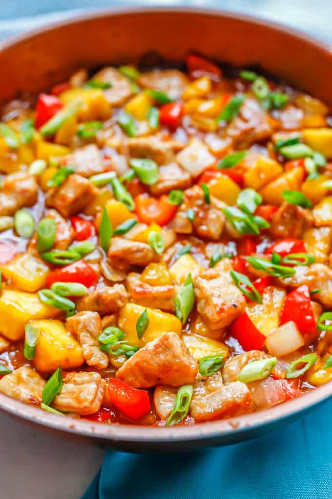 Close up of sweet and sour pork cooked in a large copper skillet