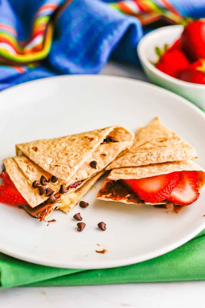 A folded dessert wrap with strawberries, bananas, Nutella and mini chocolate chips in a whole wheat tortilla