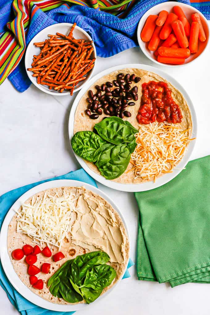 Two vegetarian tortillas with different ingredients in four quadrants before being folded up