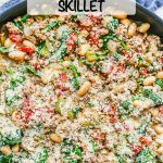 A skillet full of ground turkey, white beans, tomatoes and spinach with Parmesan cheese on top and a text overlay on the photo