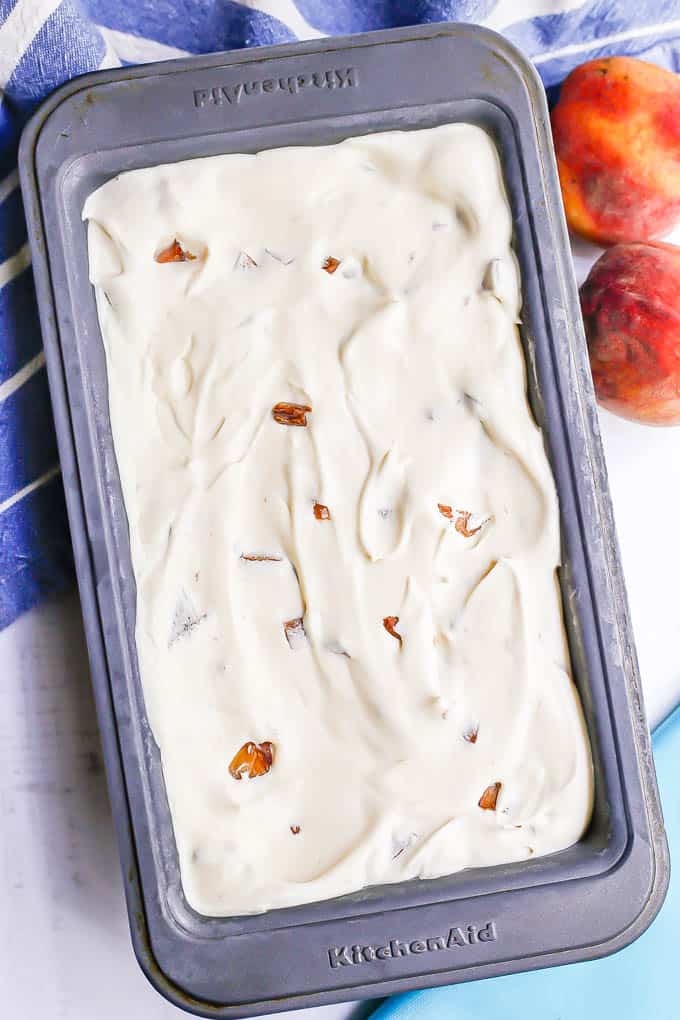 Peach ice cream in a container after being frozen