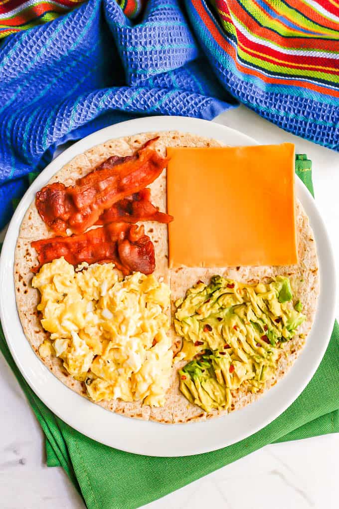 A breakfast folded wrap with scrambled eggs, bacon, cheddar and smashed avocado