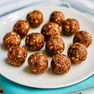A round white plate full of chocolate peanut butter energy balls