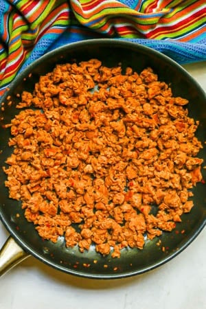 Crumbled, cooked turkey sausage in a large dark skillet