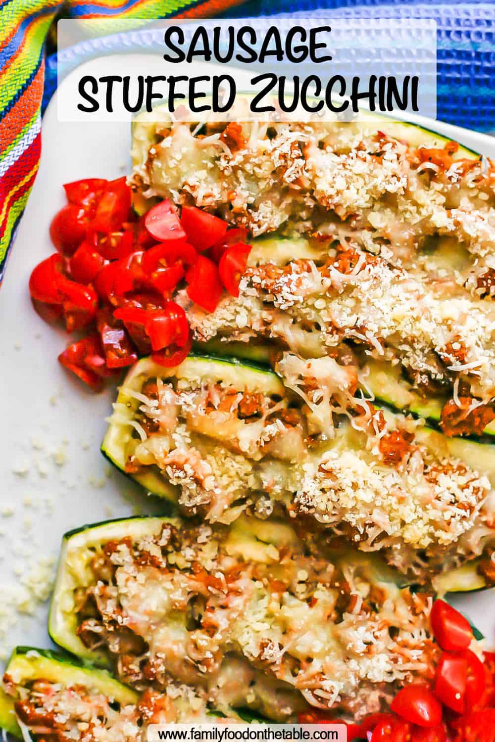 Baked stuffed zucchini served on a white plate with chopped fresh tomatoes on top and a text overlay on the photo