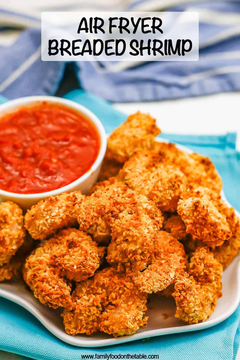 Close up of crispy Air Fryer breaded shrimp served on a white plate with a bowl of marinara with a text overlay on the photo