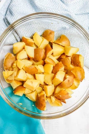 Cubed cooked Yukon potatoes in a glass bowl