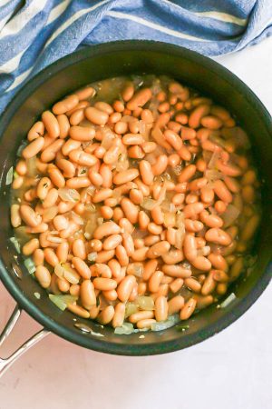 White beans being simmered in a pot on the stove