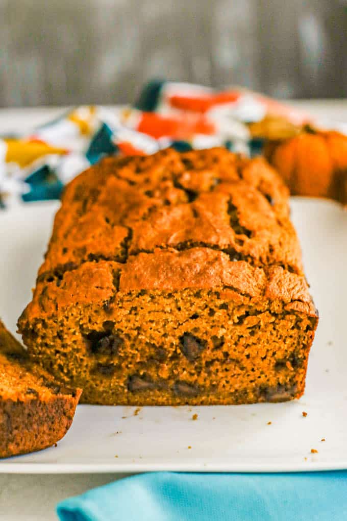 A sliced loaf of healthy pumpkin bread on a rectangular white serving plate