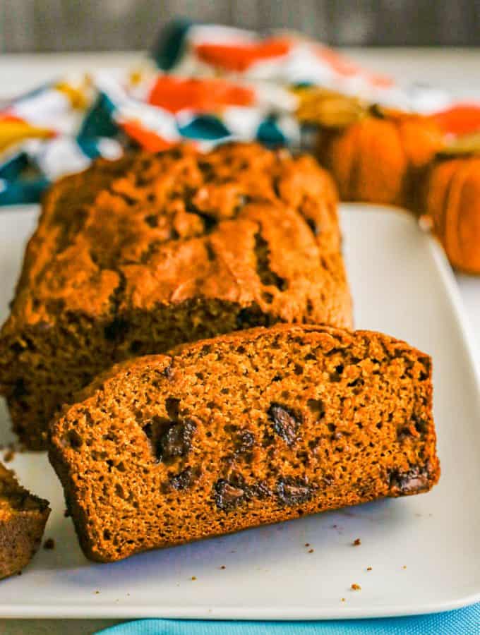 Close up of a slice of pumpkin bread with chocolate chips sliced on a white plate