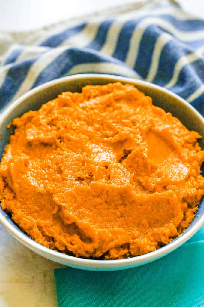 A blue and white serving bowl with mashed sweet potatoes