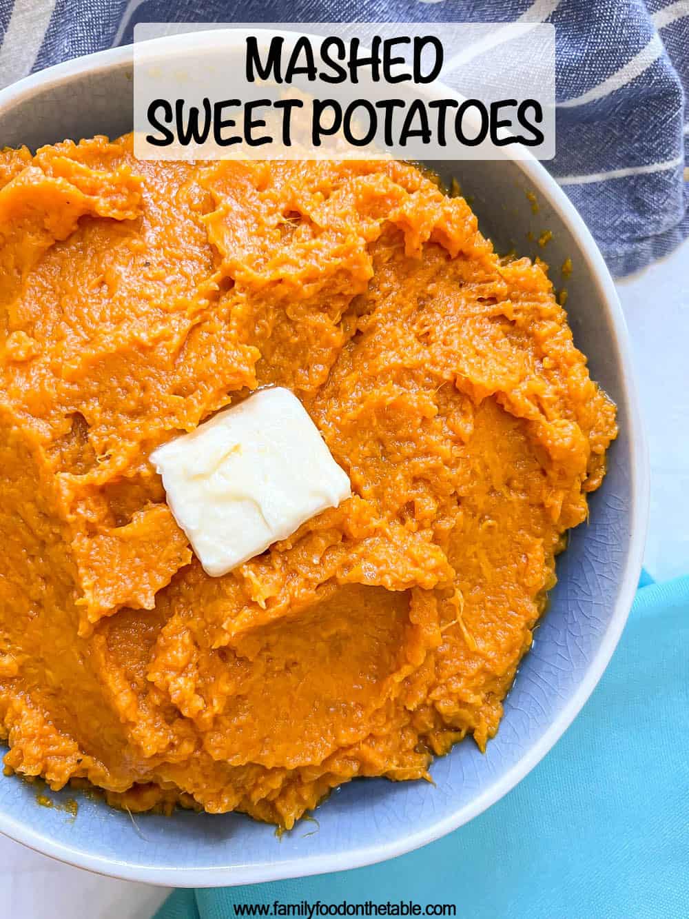 Close up of creamy mashed sweet potatoes in a blue serving bowl with a pat of butter on top and a text overlay on the photo