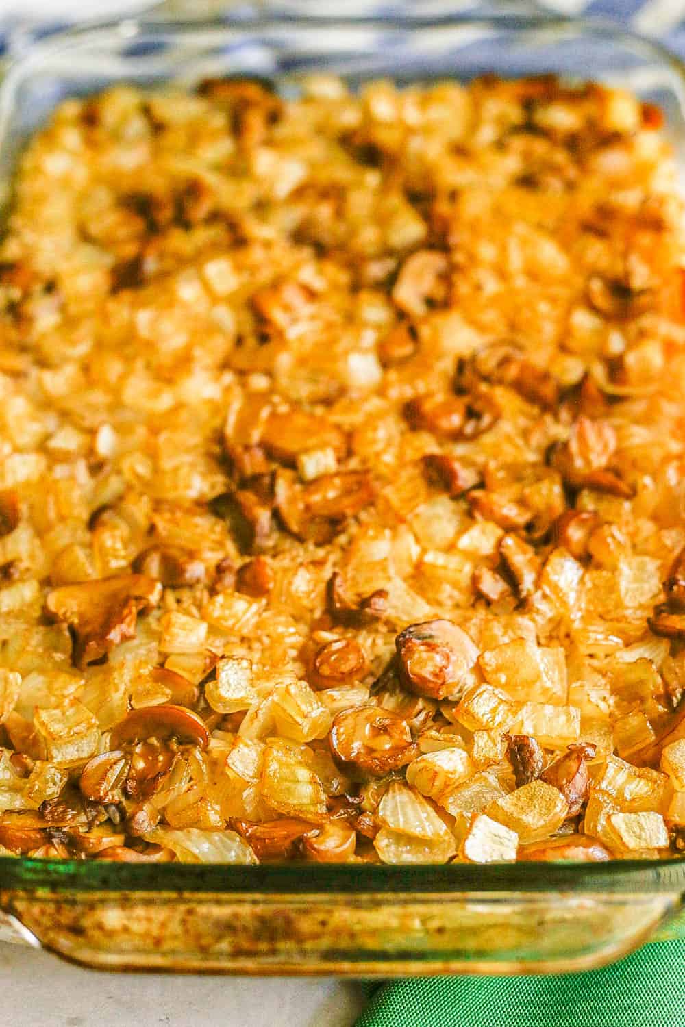 Close up of a baked mushroom rice casserole with onions in a large glass baking dish