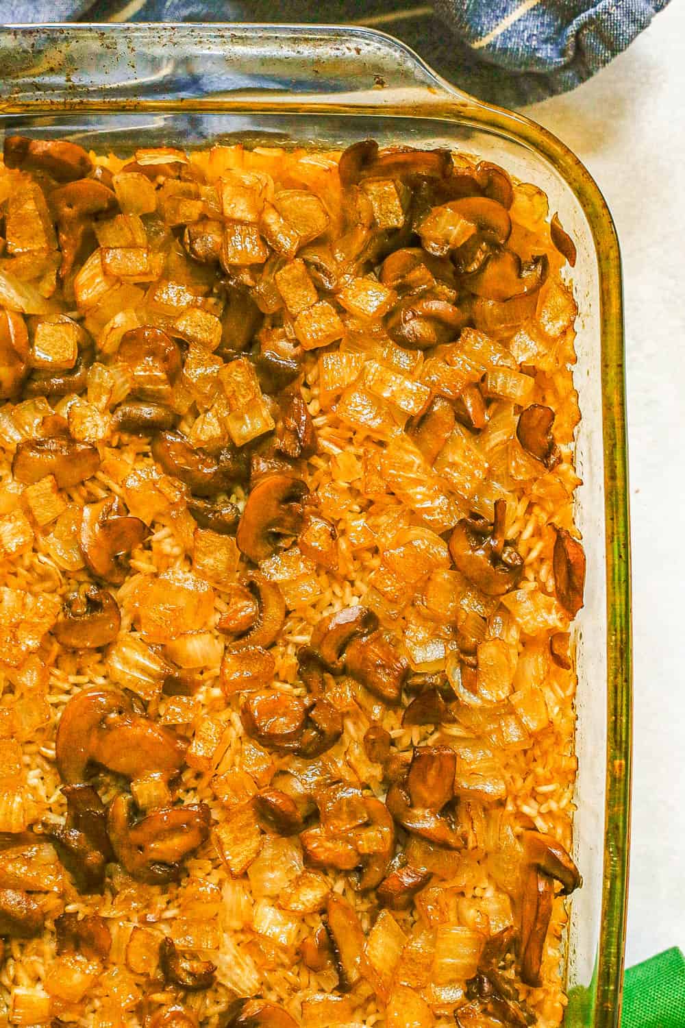 A baked rice casserole with mushrooms and onions in a large glass baking dish