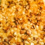 Close up of a baked mushroom rice casserole with onions in a large glass baking dish with a text overlay on the photo