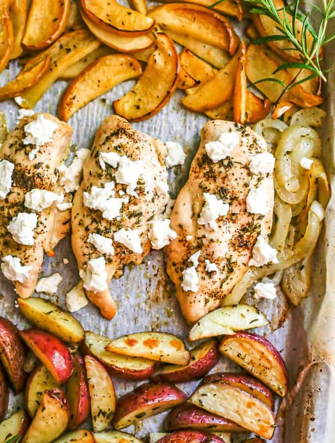 Roasted chicken breasts with apples, onions and potatoes on a sheet pan