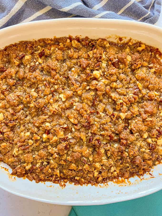Classic sweet potato casserole in a white baking dish with a golden brown and crunchy pecan streusel topping