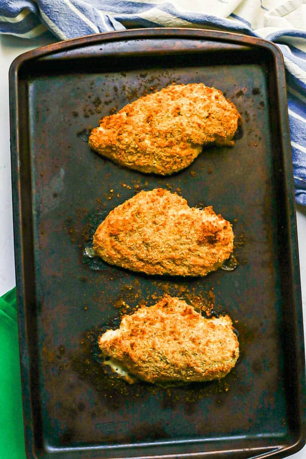 Crispy browned breadcrumb coated chicken breasts on a sheet pan after being cooked