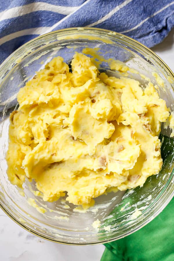 Mashed Yukon potatoes in a glass bowl