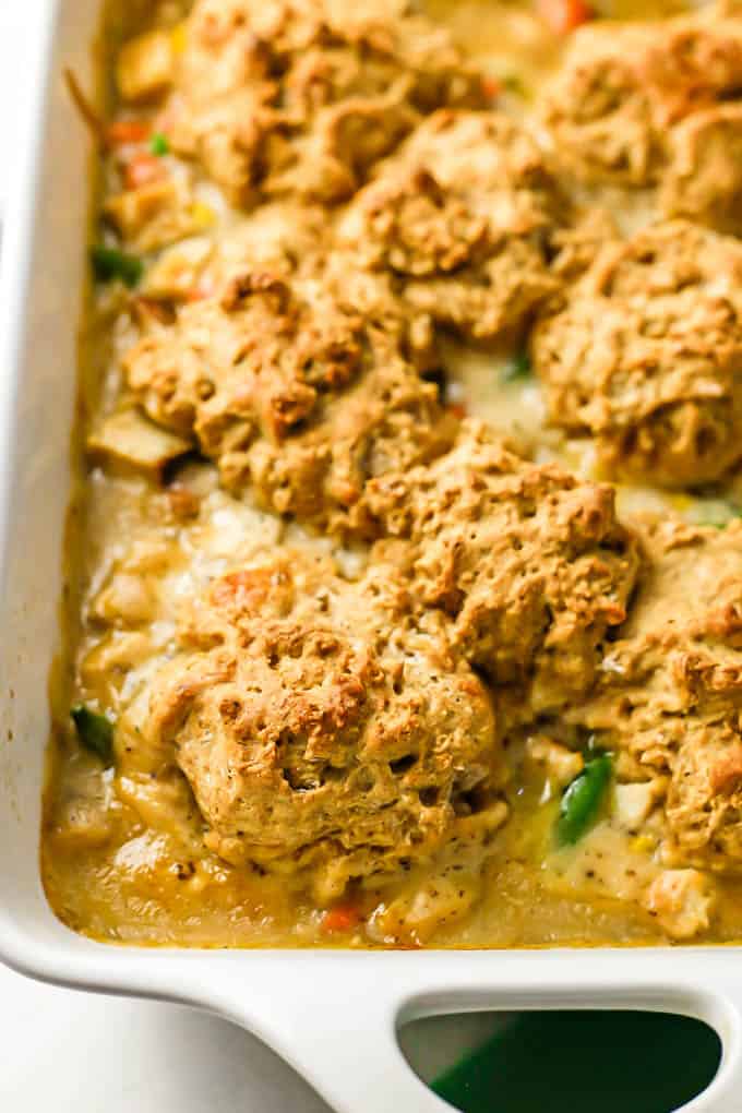 Close up of biscuit topped turkey pot pie in a white casserole dish after being baked