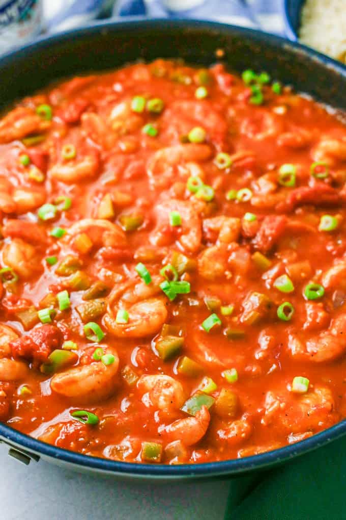 Quick shrimp creole in a large skillet topped with sliced green onions.