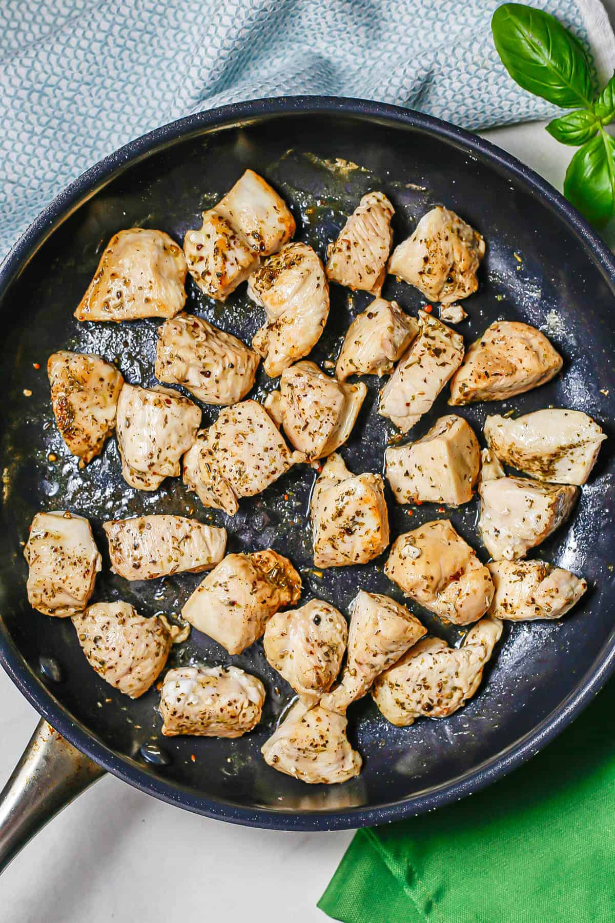 Seared cubed chicken in a skillet.