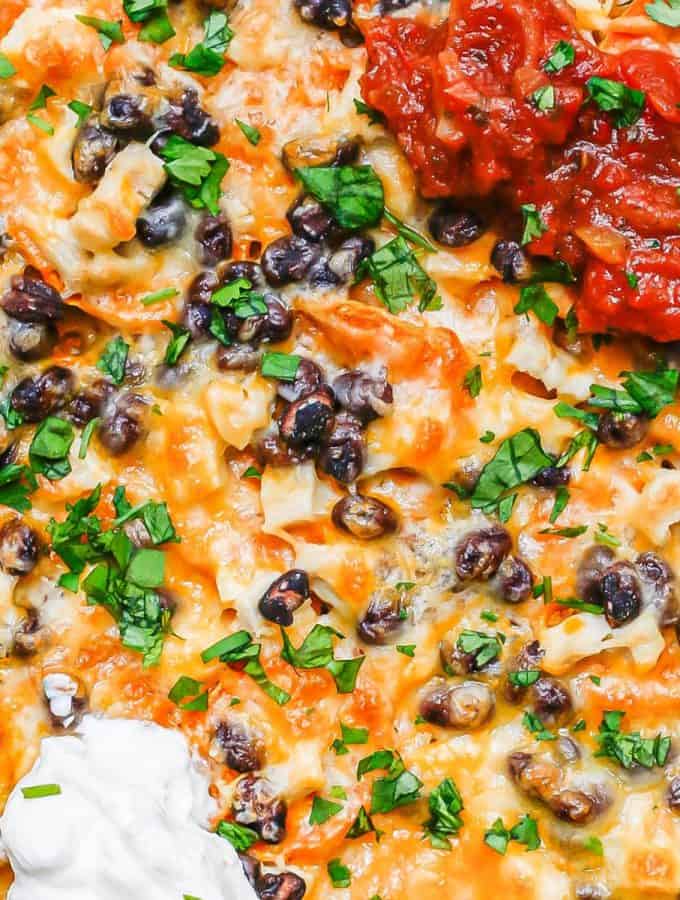 Loaded cheesy sweet potato nachos topped with salsa and sour cream.