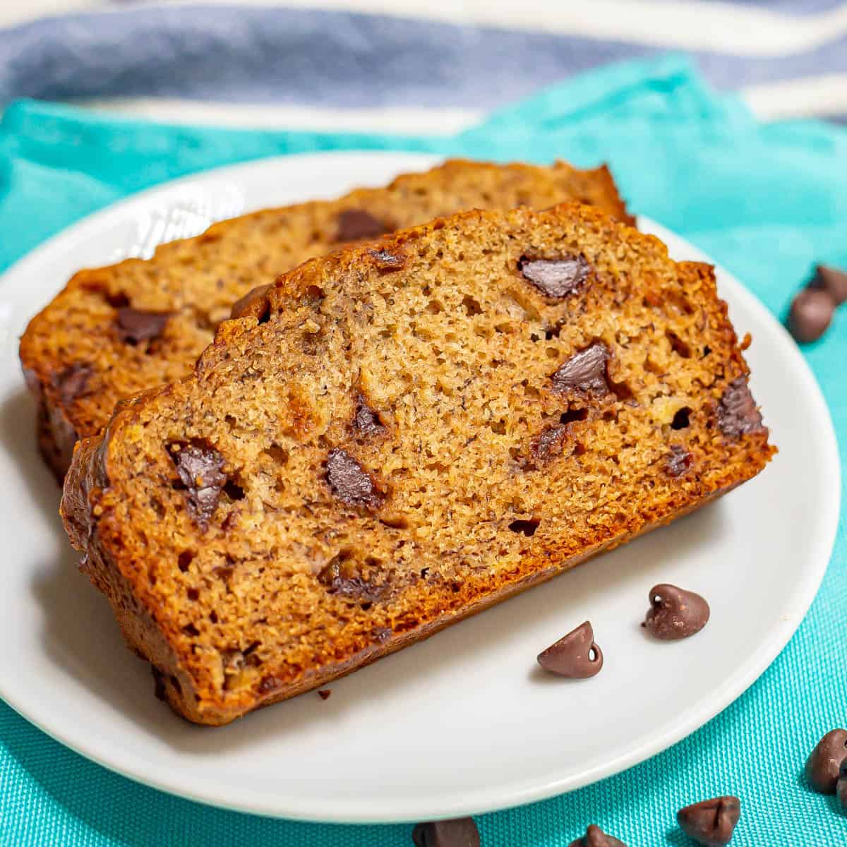 Close up of a slice of chocolate chip banana bread served on a white round plate.