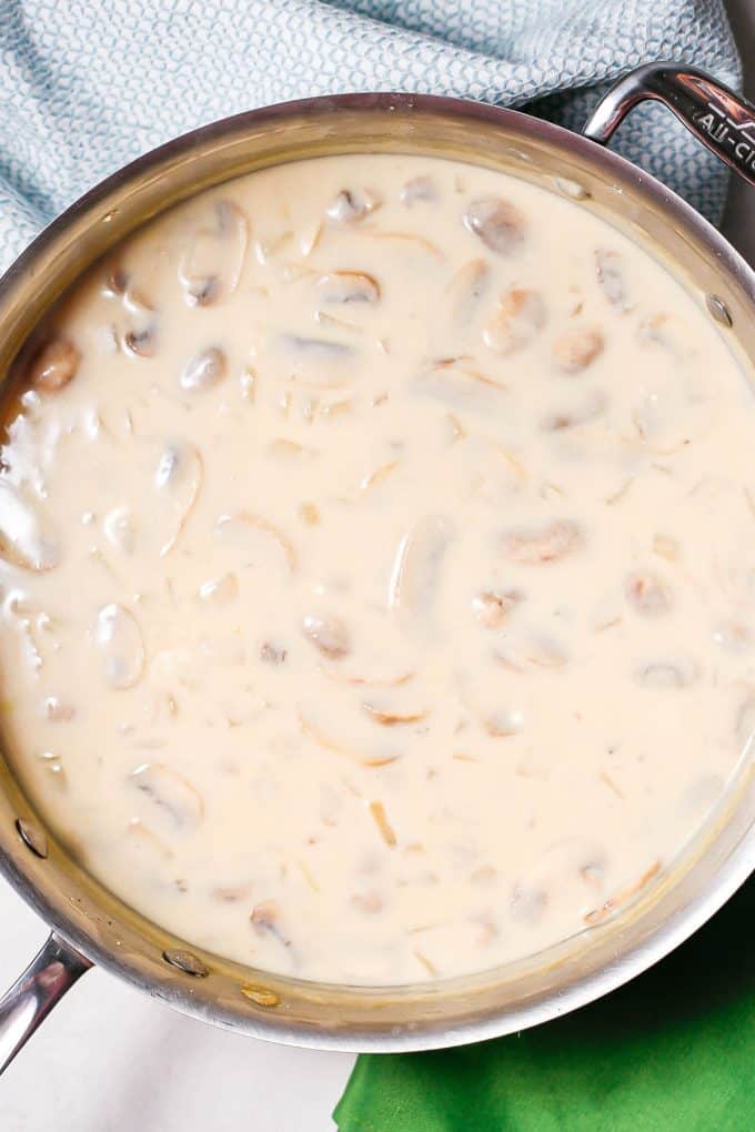 A creamy mushroom sauce in a large all-clad pan.