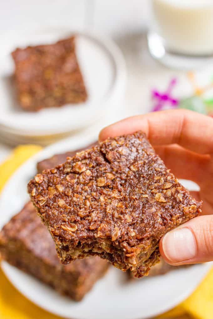A hand holding a no bake cookie bar with a bite taken out.