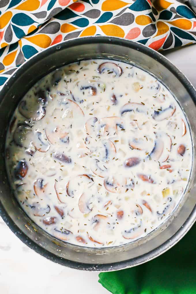 A large dark pot with a creamy mushroom mixture.