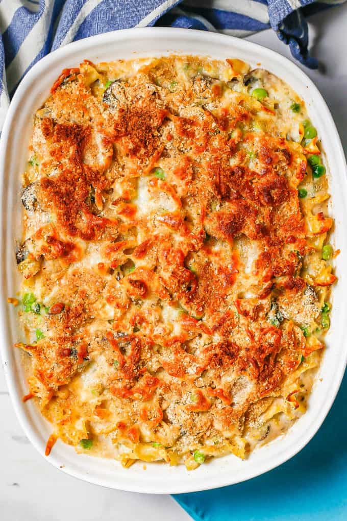 Baked tuna noodle casserole in a white dish with a crunchy browned topping.