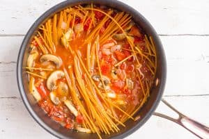 A one pot pasta dish in a pot before being fully cooked.