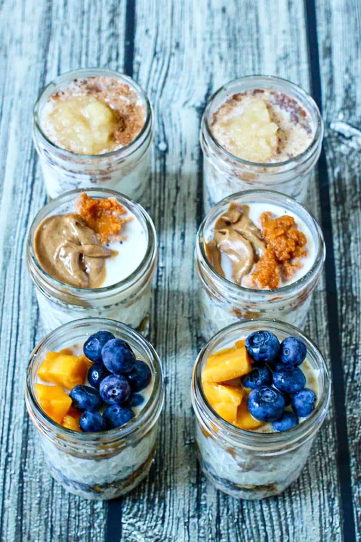 Six glass jars filled with different flavors of overnight oats.