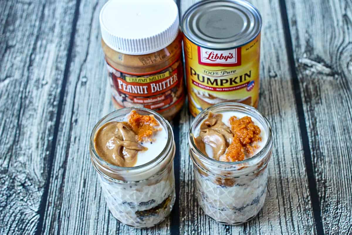 Two glass jars with peanut butter and pumpkin topped overnight oats.