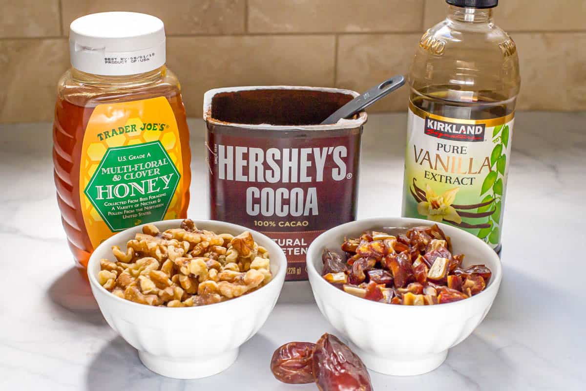 5 ingredients lined up on a counter for making raw date brownies.