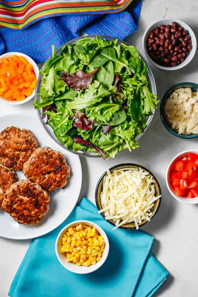 Ingredients laid out in separate bowls to make turkey burger salads.