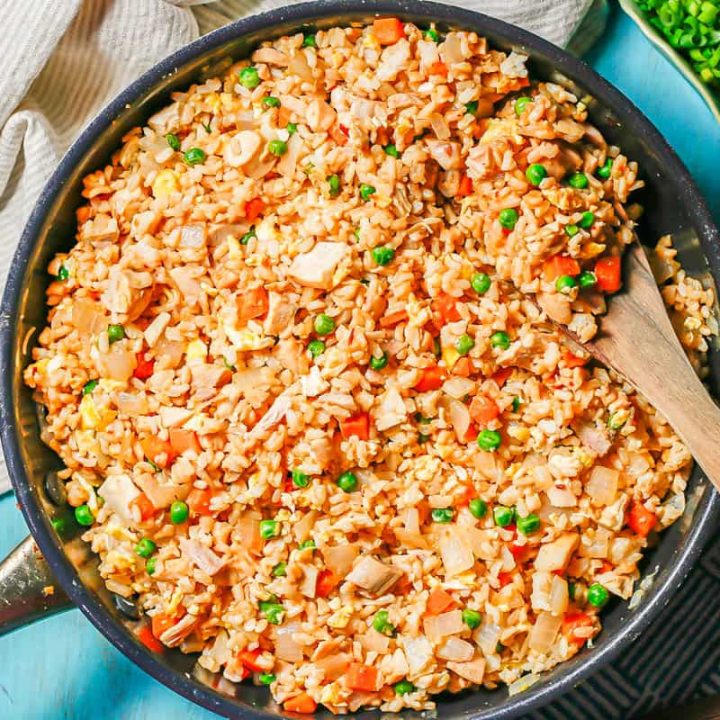 A skillet being served up with chicken fried rice.