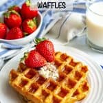 Healthy homemade waffles topped with butter, maple syrup and strawberries with milk and strawberries in the background and a text overlay on the photo.